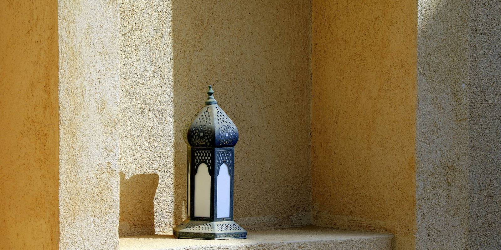 Lanterne marocaine posée dans une niche aux murs de chaux