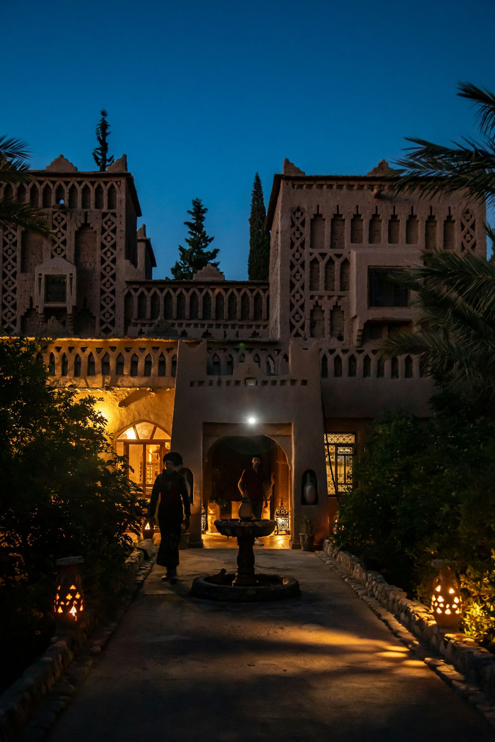 Cour de riad la nuit, allée éclairée par des lanternes