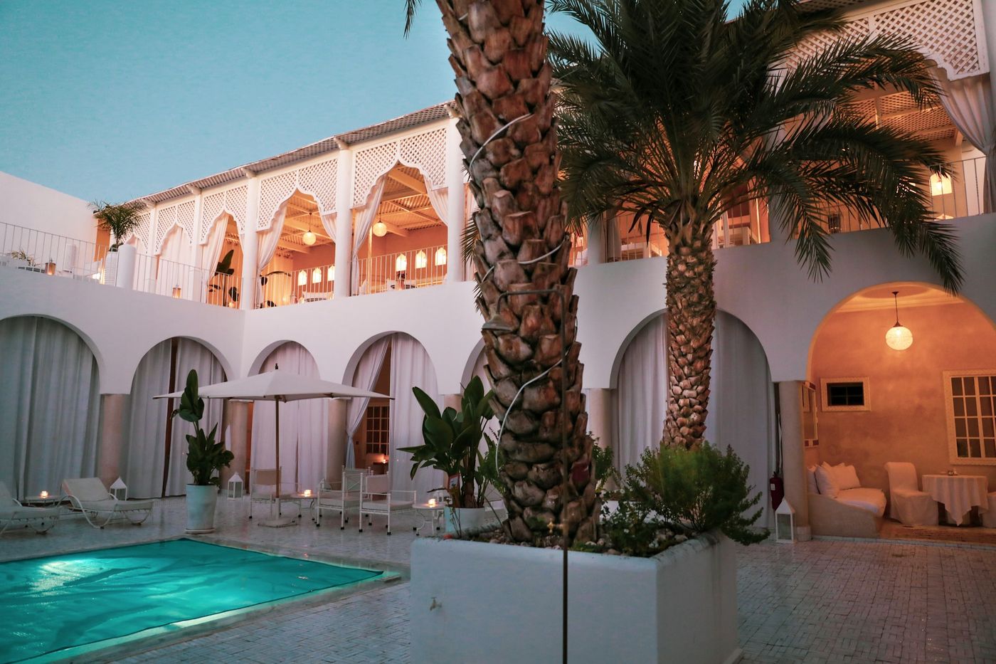 Patio d'un riad avec bassin et palmiers à Marrakech
